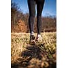 Jogging outdoors in a meadow (shallow dof, focus on the running shoe)