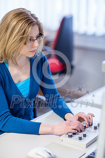 Pretty, female researcher using a microscope in a lab, doing research (color toned image)