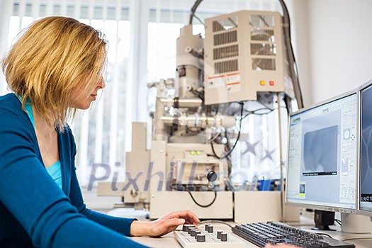 Pretty, female researcher using a microscope in a lab, doing research (color toned image) Pretty, female researcher using a microscope in a lab, doing research (color toned image)