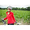 Pretty, young female biker outdoors on her mountain bike (shallow DOF; selective focus)