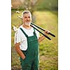 Portrait of a handsome senior man gardening in his garden, on a lovely spring day (color toned image)