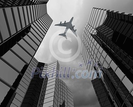 Bottom view of airplane flying above skyscrapers