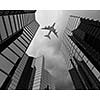 Bottom view of airplane flying above skyscrapers