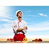 Young cheerful cook and ingredients flying in air