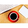 Cup of coffee notepad and keyboard on wooden table