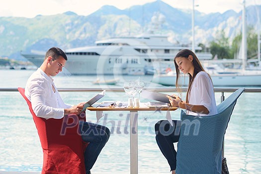 happy young couple having lanch at beautiful restaurant on by the sea on beach happy young couple having lanch at beautiful restaurant on by the sea on beach