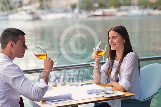 happy young couple having lanch at beautiful restaurant on by the sea on beach happy young couple having lanch at beautiful restaurant on by the sea on beach