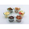 nuts and dry fruits mix healthy organic food mix in glass bowls isolated on white background
