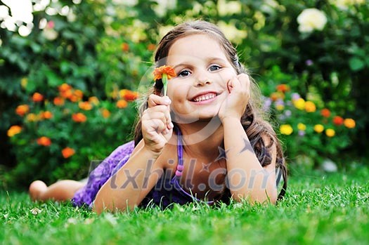 happy young girl children relax lie and have fun on grass with flower