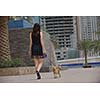 beautiful happy young  woman in black dress with cute small dog puppy have fun on street