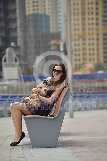 beautiful happy young woman in black dress with cute small dog puppy have fun on street beautiful happy young woman in black dress with cute small dog puppy have fun on street