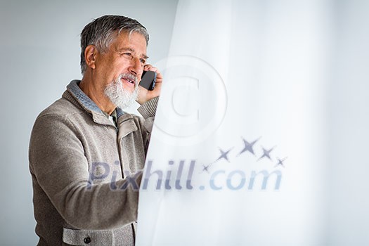 Handsome senior man calling on his cell phone and looking from a window at his house (shallow DOF; color toned image) Handsome senior man calling on his cell phone and looking from a window at his house (shallow DOF; color toned image)