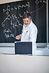 Senior chemistry professor writing on the board while having a chalk and blackboard lecture (shallow DOF; color toned image)