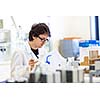 Male researcher carrying out scientific research in a lab (shallow DOF; color toned image)