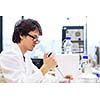 Male researcher carrying out scientific research in a lab (shallow DOF; color toned image)