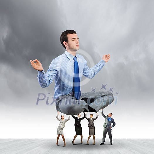 Young businessman sitting in lotus pose and supported by colleagues Young businessman sitting in lotus pose and supported by colleagues