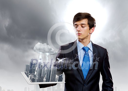 Handsome businessman holding model of modern city Handsome businessman holding model of modern city