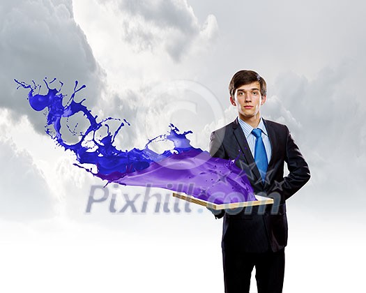 Handsome businessman holding frame with colorful splashes Handsome businessman holding frame with colorful splashes