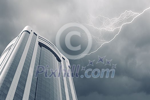 Bottom image of skyscraper with thunder lightning in sky