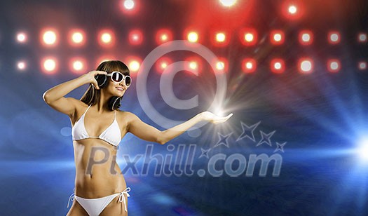 Young attractive girl in bikini wearing headphones touching media icon Young attractive girl in bikini wearing headphones touching media icon