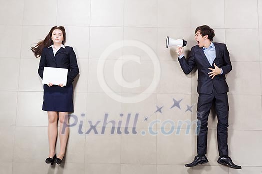 Angry businessman shouting in megaphone on his colleague Angry businessman shouting in megaphone on his colleague