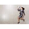 Funny image of businesswoman running with megaphone in hands