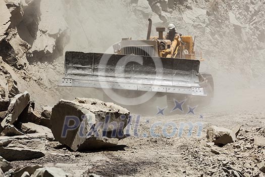 Bulldozer cleaning landslide from road in Himalayas. Himachal Pradesh, India