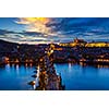 Aerial view of illuminated Prague castle and Charles Bridge with tourist crowd over Vltava river in Prague, Czech Republic. Prague, Czech Republic in the evening