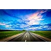 Travel concept background - road and stormy dramatic sky on sunset