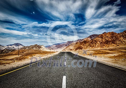 Travel forward concept background - road in Himalayas mountains and dramatic clouds. Ladakh, Jammu and Kashmir, India