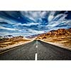 Travel forward concept background - road in Himalayas mountains and dramatic clouds. Ladakh, Jammu and Kashmir, India