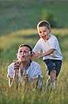 happy child and woman outdoor playing with soap bubble on meadow