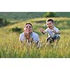 happy child and woman outdoor playing with soap bubble on meadow