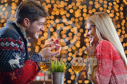 The young man gives a wedding ring   gift to  girl in restaurant