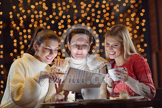 happy girls group looking at a pc tablet in a home interior and have fun happy girls group looking at a pc tablet in a home interior and have fun