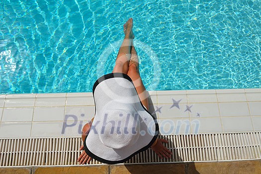 Happy smiling woman with hat and sunglasses in swimming pool at tropical resort Happy smiling woman with hat and sunglasses in swimming pool at tropical resort