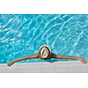 Happy smiling woman with hat and sunglasses  in swimming pool at tropical resort