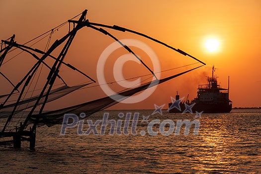 Kochi chinese fishnets on sunset and modern ship. Fort Kochin, Kochi, Kerala, India
