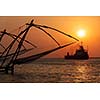 Kochi chinese fishnets on sunset and modern ship. Fort Kochin, Kochi, Kerala, India