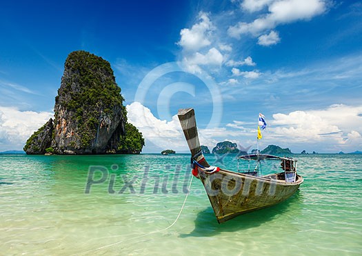 Long tail boat on tropical beach (Pranang beach) and rock, Krabi, Thailand