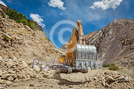 Excavator doing road construction in Himalayas. Ladakh, Jammu and Kashmir, India Excavator doing road construction in Himalayas. Ladakh, Jammu and Kashmir, India