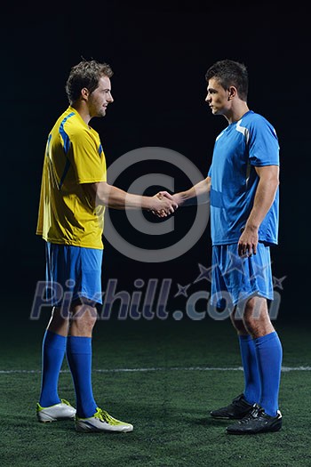 soccer player doing kick with ball on football stadium field isolated on black background soccer player doing kick with ball on football stadium field isolated on black background