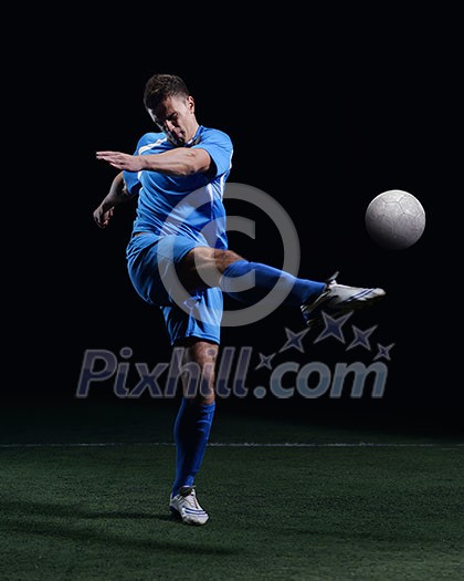 soccer player doing kick with ball on football stadium field isolated on black background soccer player doing kick with ball on football stadium field isolated on black background
