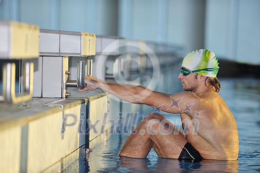 start position race concept with fit swimmer on swimming pool start position race concept with fit swimmer on swimming pool
