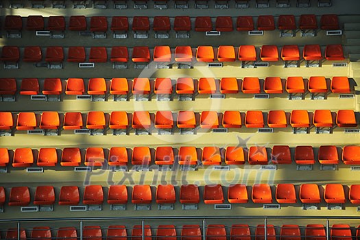 many empty orange seats in sport arena representing audience and crowd concept