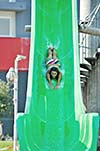 happy girl have fun  on water slide at outdoor swimming pool