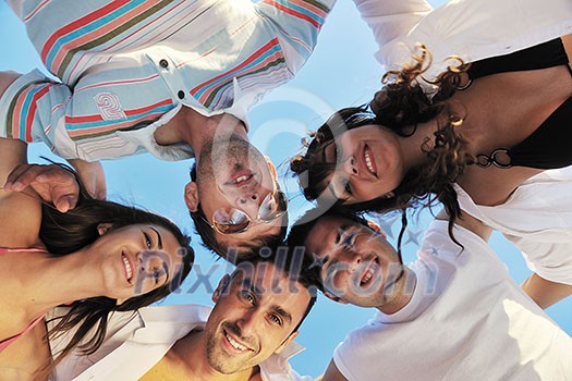 happy young friends group team huging have fun and celebrate  on the beach at the sunset