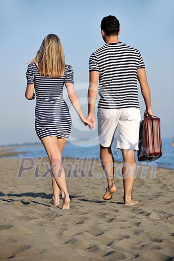 couple on beach with travel bag representing freedom and funy honeymoon concept couple on beach with travel bag representing freedom and funy honeymoon concept