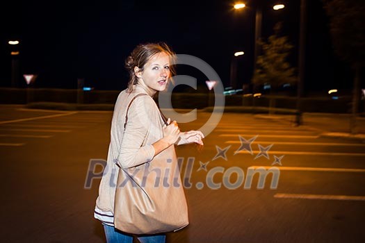 Scared young woman running from her pursuer in a deserted parking lot Scared young woman running from her pursuer in a deserted parking lot