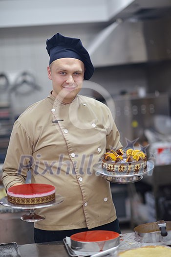 Closeup of a concentrated male pastry chef decorating dessert cake food in the kitchen